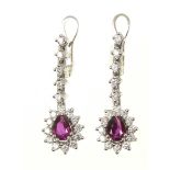 A pair of ruby and diamond earrings Each designed as a pear shaped ruby and brilliant cut diamond