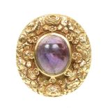 A 1970s 9ct gold amethyst dress ring The oval amethyst cabochon within a floral surround, to the