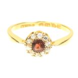 An early 20th Century 18ct gold garnet and diamond cluster ring The circular shaped garnet within an