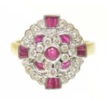 A ruby and diamond cluster ring The circular ruby collet within a brilliant cut diamond and vari