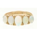 A 9ct gold opal five stone ring The graduated oval opal cabochon line with tapered shoulders,