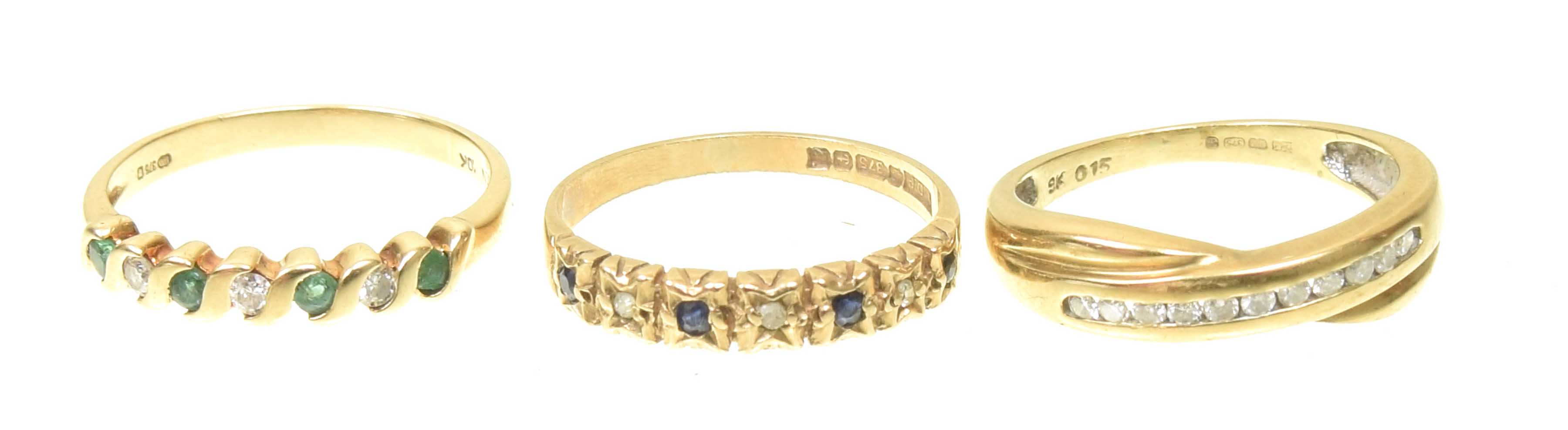 Three 9ct gold gem-set band rings To include a diamond band ring, an emerald and diamond band