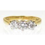 An 18ct gold diamond three stone ring The brilliant cut diamond line with tapered shoulders,
