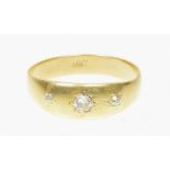 A diamond three stone ring The old cut diamond line inset to the tapered band, stamped 18ct, ring