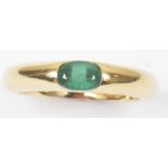 An 18ct gold emerald single stone ring The oval shaped emerald, horizontally set to the polished