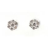 A pair of platinum diamond cluster earrings Each designed as a brilliant cut diamond, within a