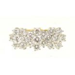 An 18ct gold diamond cluster ring Designed as a trio of brilliant cut diamond floral clusters,