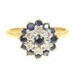 A sapphire and diamond cluster ring The circular shape sapphire, within a brilliant cut diamond