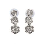 A pair of diamond earrings Each designed as a series of graduated brilliant cut diamond clusters,