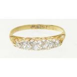 An 18ct gold diamond five stone ring The brilliant cut diamond line with scrolling shoulders,