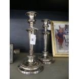 A pair of silver-plated candlesticks With a circular base, tapered stem and embossed floral