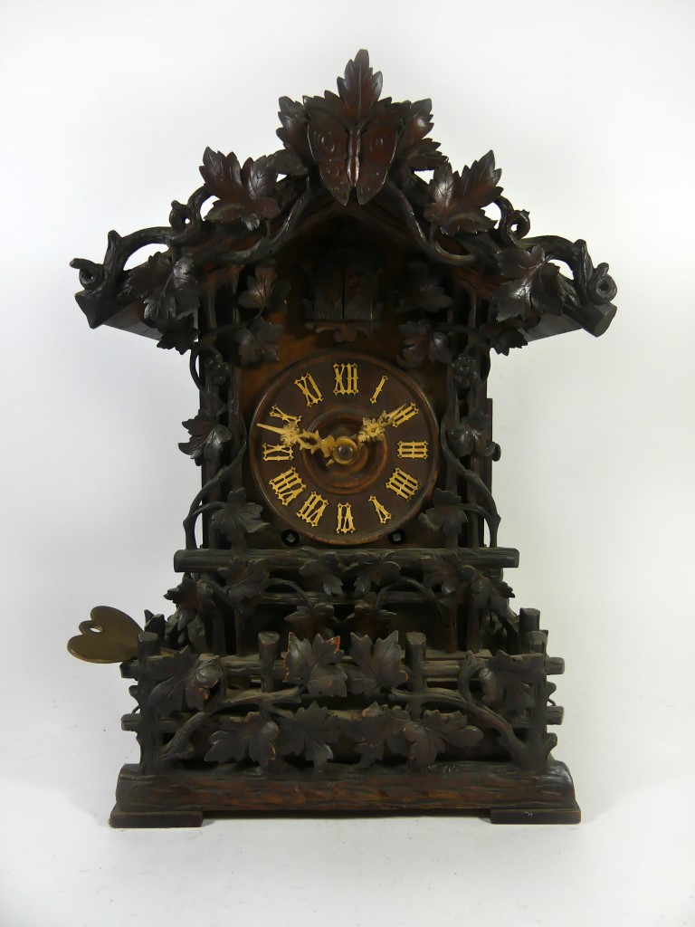 A Victorian Black Forest carved wood cuckoo mantle clock Carved with oak leaves, central butterfly