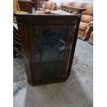 A 19th Century glazed mahogany hanging corner cupboard Having a moulded cornice above a frieze