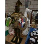 A large brass figure of a knight The knight in traditional attire, together with a ceramic figure of