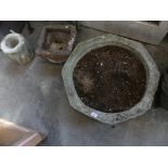 A reconstituted stone urn planter Of octagonal form, on a plinth base.