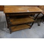 An early 20th Century oak open bookcase with leaf carved uprights and a chiseled frieze.