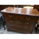 A George III mahogany chest of two short and three long drawers with canted corners.