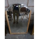An Art Deco shaped wall mirror with an etched beveled border.
