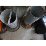 Two cylindrical galvanised metal poultry feeders.