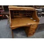 An early 20th Century golden oak roll top desk