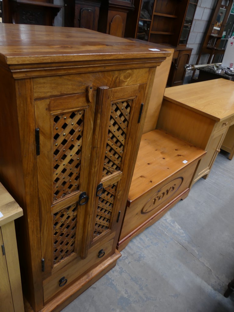 A Contemporary hardwood cabinet with a pair of lattice open work doors above a single drawer.