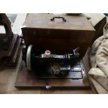 A wooden cased Singer sewing machine Together with a red painted trunk.