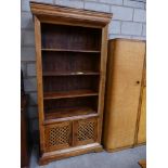 A contemporary hardwood open book shelf With three shelves above a pair lattice cupboard doors