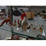 A Beswick model of a huntsman on a grey horse Along with nine Beswick hounds and five Beswick foxes.