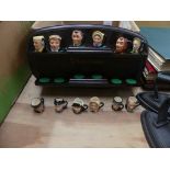 A collection of ten miniature Royal Doulton character jugs To a hardwood rack.