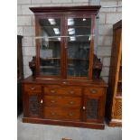 A Victorian walnut glazed bookcase With two glazed doors above an arrangement of five drawers and