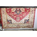 A Heriz style carpet with tasseled borders upon a red ground. (280 x 200cm)