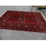 A modern wool rug With a geometric design, upon a red ground.