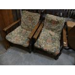 A pair of 1920's oak reclining arm chairs Each chair with turned spindles and barley twist uprights.