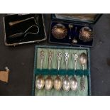 A cased pair of shell form silver salts, a cased two piece silver christening set and a set of six