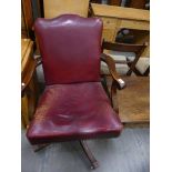 An Early 20th Century read leather revolving desk chair.