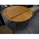 An Ercol light elm oval extending kitchen table.