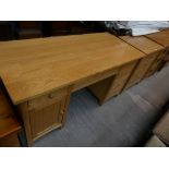 A Contemporary light oak twin pedestal desk with a conforming 3 drawer filing chest.