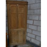 A 19th Century free standing fruit wood corner cupboard with two panel doors above two doors.