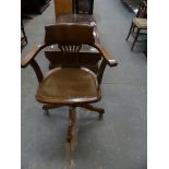 An early 20th century revolving office chair with a pierced splat back and padded seat.