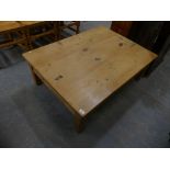 A rustic pine rectangular coffee table on legs of chamfered square section.