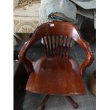 A stained beechwood revolving office chair.