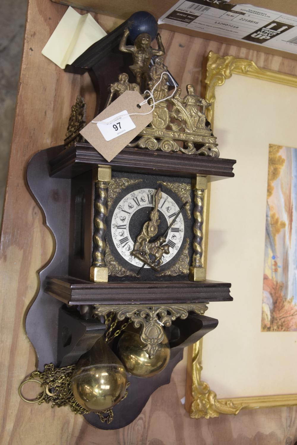 A reproduction continental brass wall clock with two substantial brass weights.