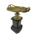 A 19th Century brass shallow tazza vase Of classical form, set on a black slate pedestal, height