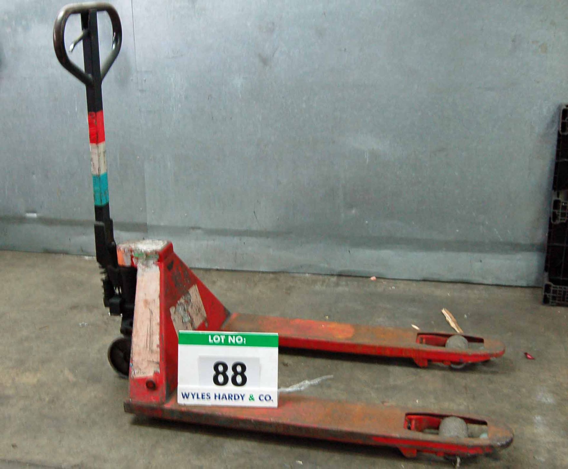 A Red Steel Manual Hydraulic Pallet Truck