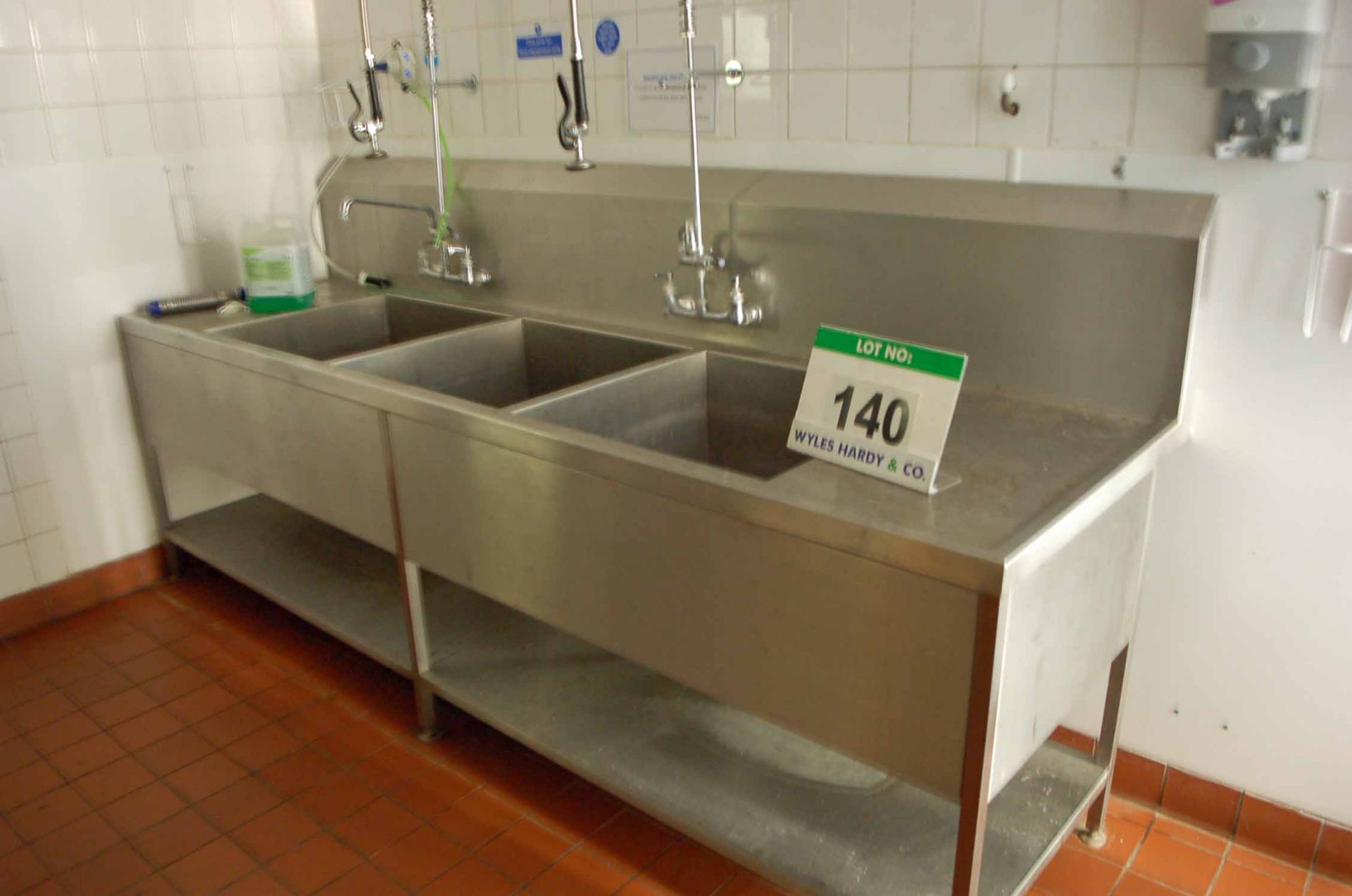 A Stainless Steel Triple Pot Wash Sink with Two Overhead Shower Lances (NOTE: Needs a Method