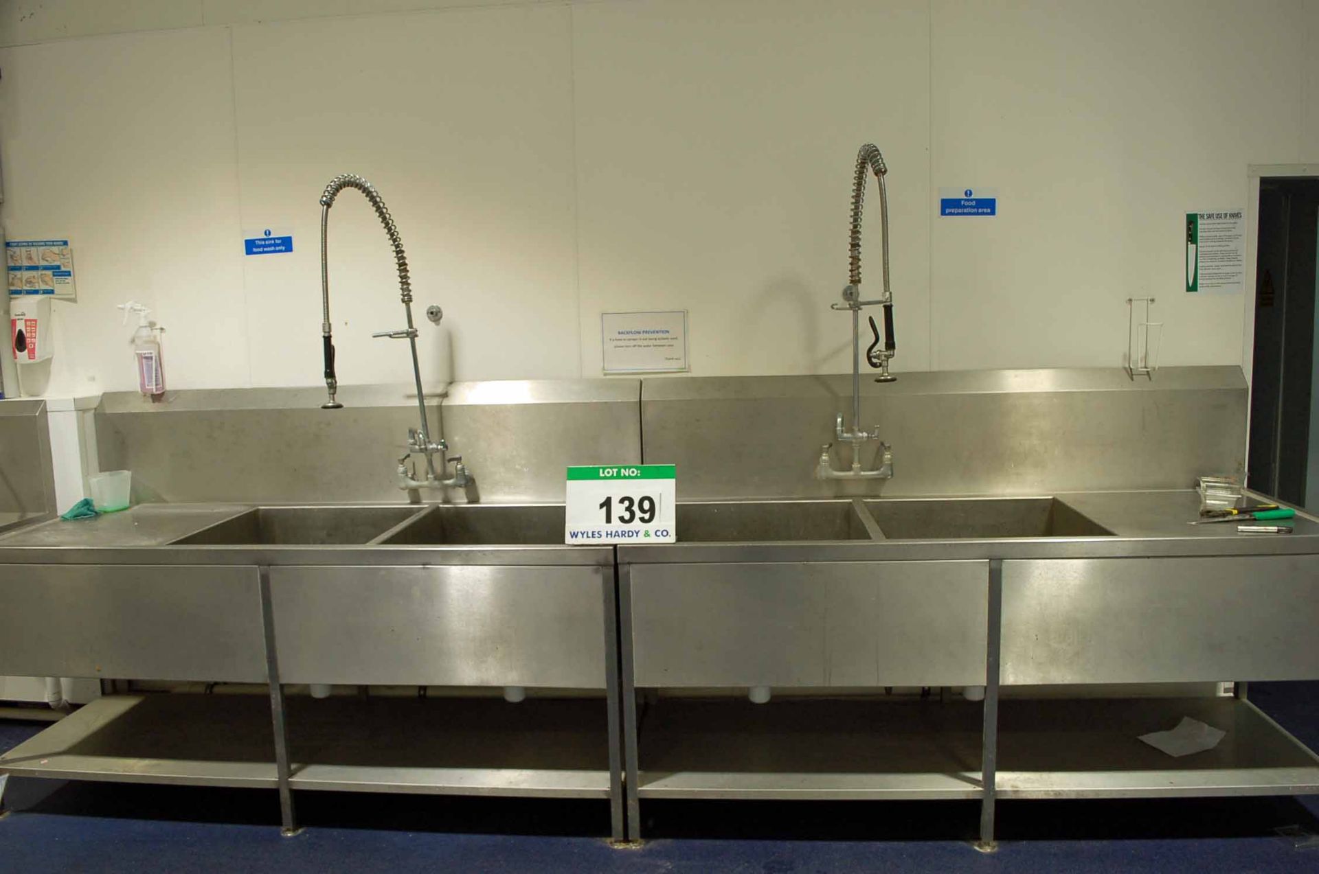 Two Stainless Steel Twin Pot Wash Sinks, each with Overhead Shower Lance (NOTE: Needs a Method
