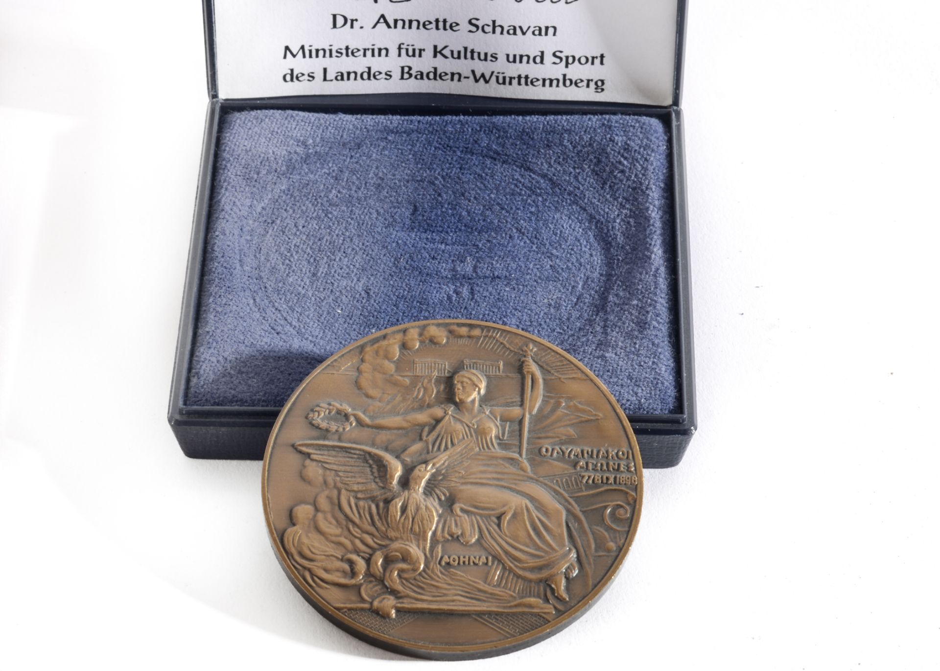 A 100 Year Commemorative Cast Metal Medal bearing a Relief of AOHNAI and the words OΛYPIAKOI ARΩ