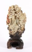 STEINSCHNITZEREI, zweiteilig, auf einem Fels sitzende Gottheit zwischen blühenden Chrysanthemen