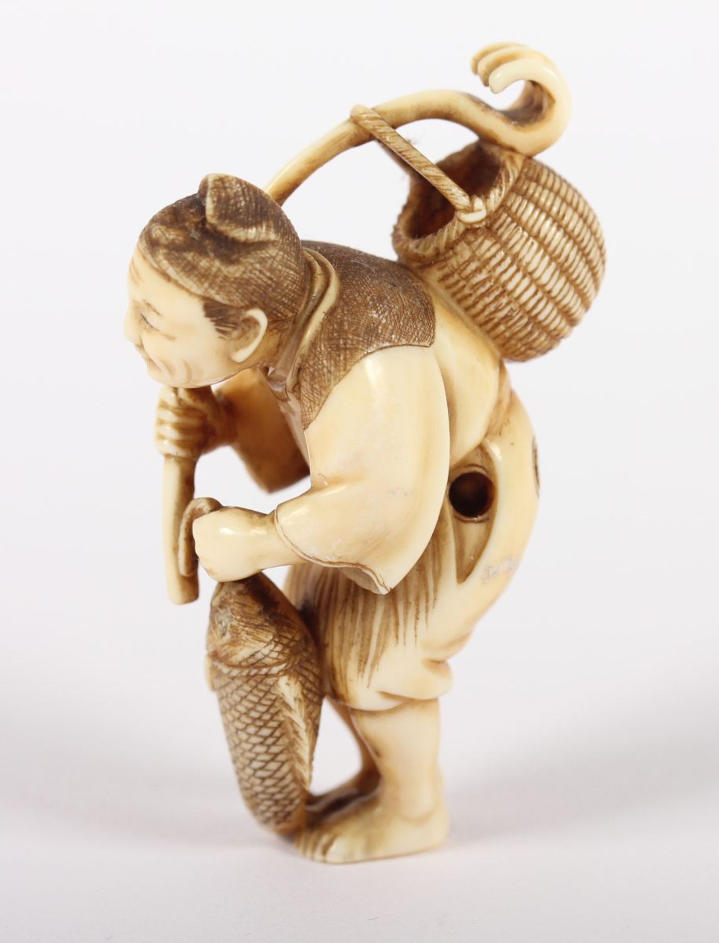 NETSUKE FISCHER, Elfenbein, der Mann mit Binsenschurz und spitzer Mütze hält in der Rechten einen - Bild 3 aus 5