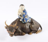 FIGÜRLICHES DECKELGEFÄSS, Porzellan, liegender Wasserbüffel mit einem auf seinem Rücken sitzenden